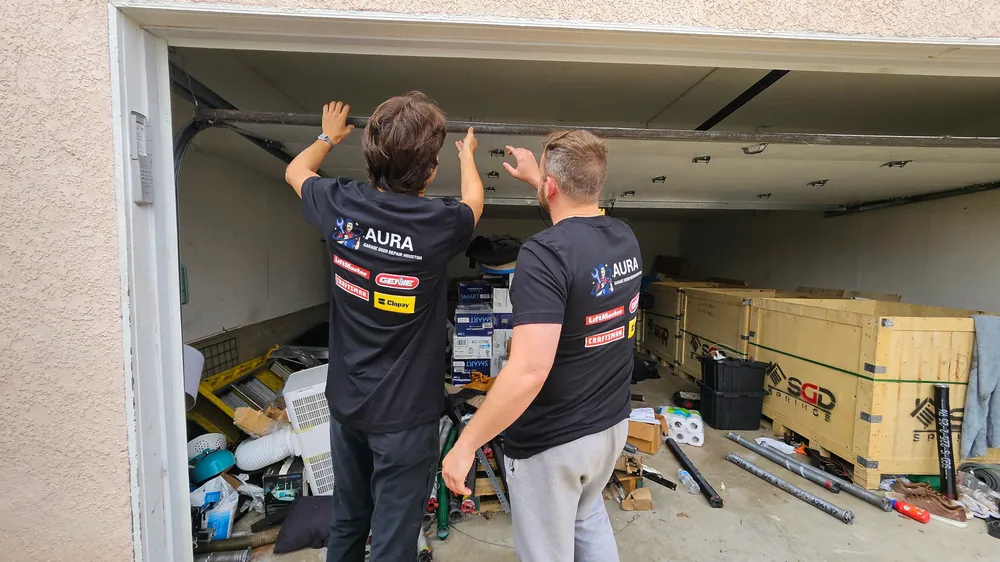 Technicians examining the torsion bar above a door