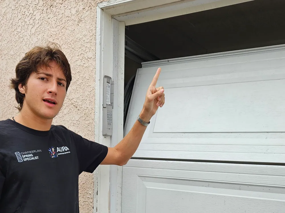 Aura technician pointing out a dropped panel on a garage door